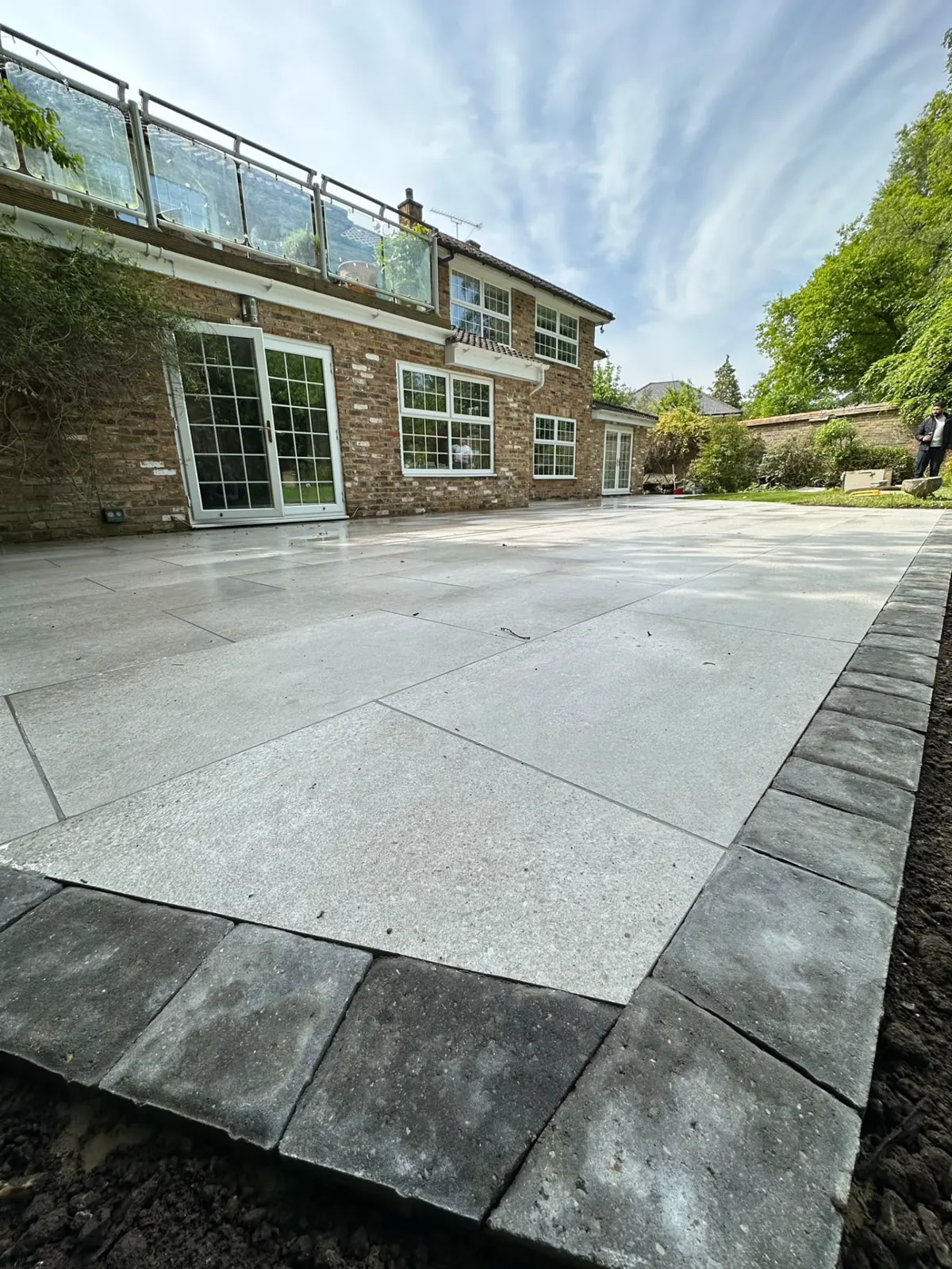 Large format grey porcelain patio with charcoal block border