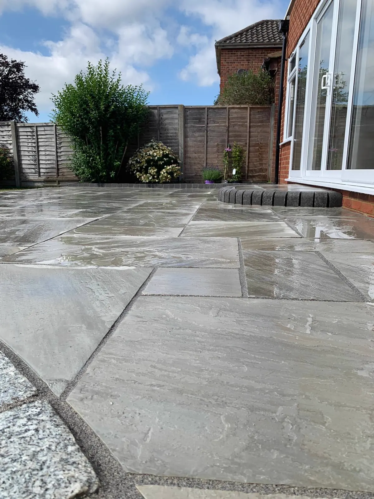 Indian sandstone patio with granite circle and raised step