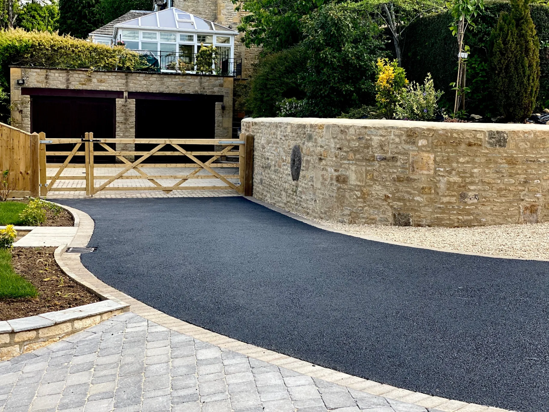 Curved tarmac driveway with block paving border installed by SureLay UK