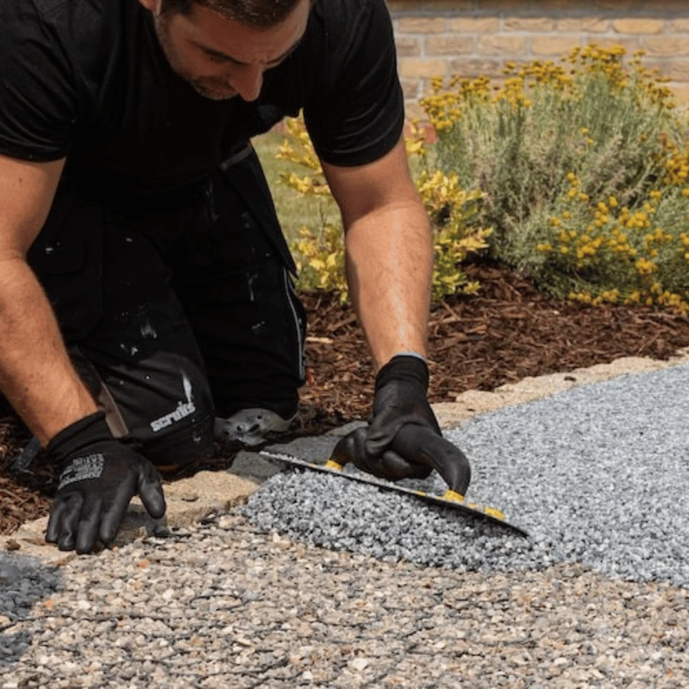 SureLay UK installation team hand-trowelling resin bound aggregate on site